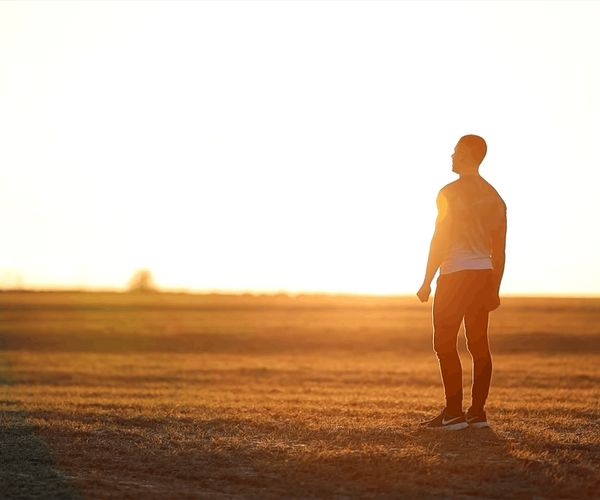 Person meditating peacefully with soft, warm background light.